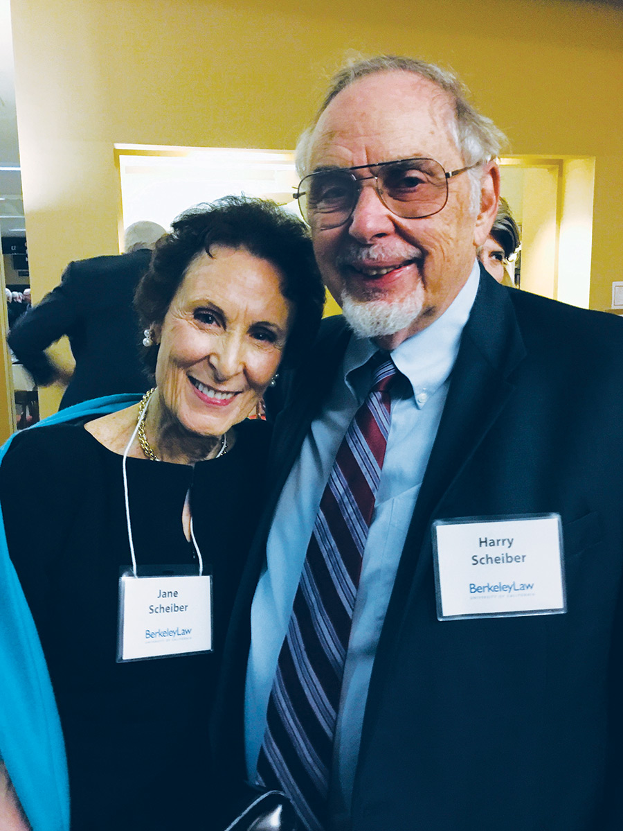 A portrait photograph of Jane L. Scheiber (left) and her husband, Professor Emeritus Harry N. Scheiber standing next to each other as they smile posing for a picture together