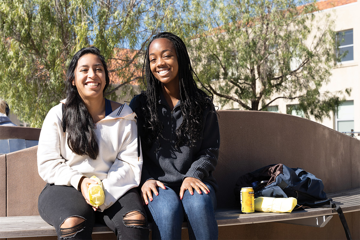 Arielle Rodriguez and Jasmin Shaw smiling on bench
