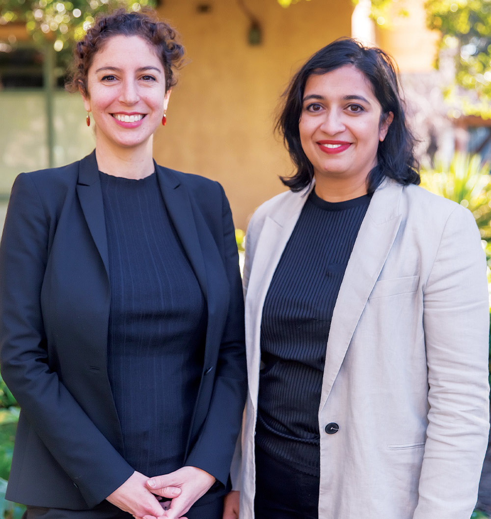 Professors Rebecca Wexler (left) and Manisha Padi smile and stand together for a portrait photo