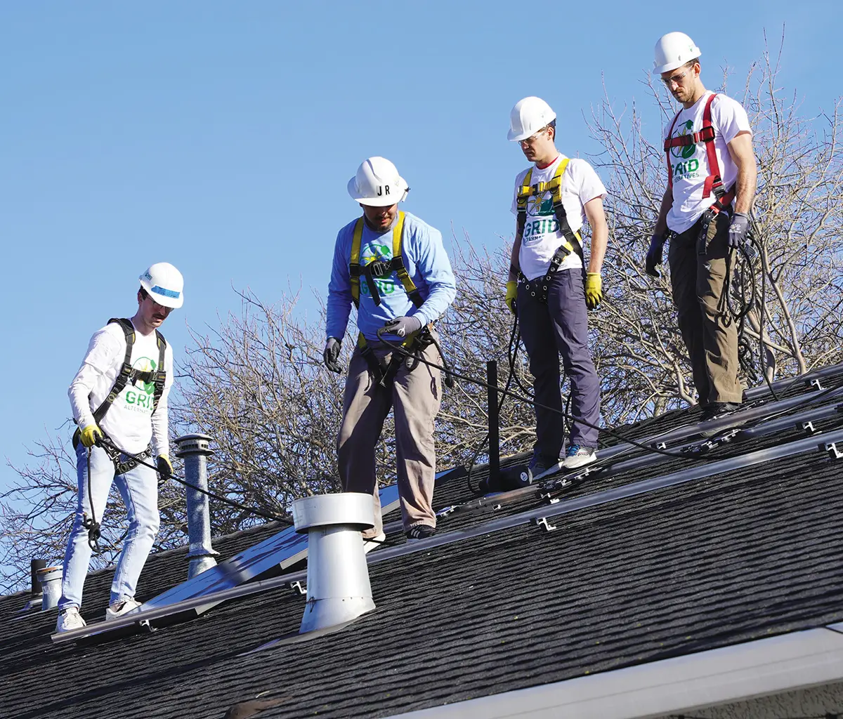 Pedro Hernandez Jr., Julius Giesen, Connor Hughes, and Cole Steinberg on roof installing solar panels