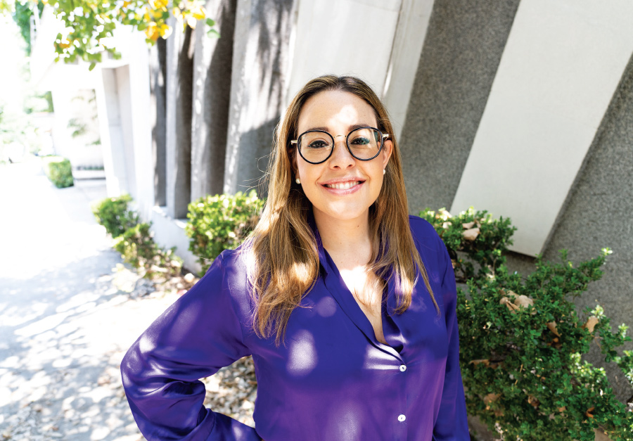 Jeanett Trad smiling in long sleeve purple button up shirt smiling with glasses on