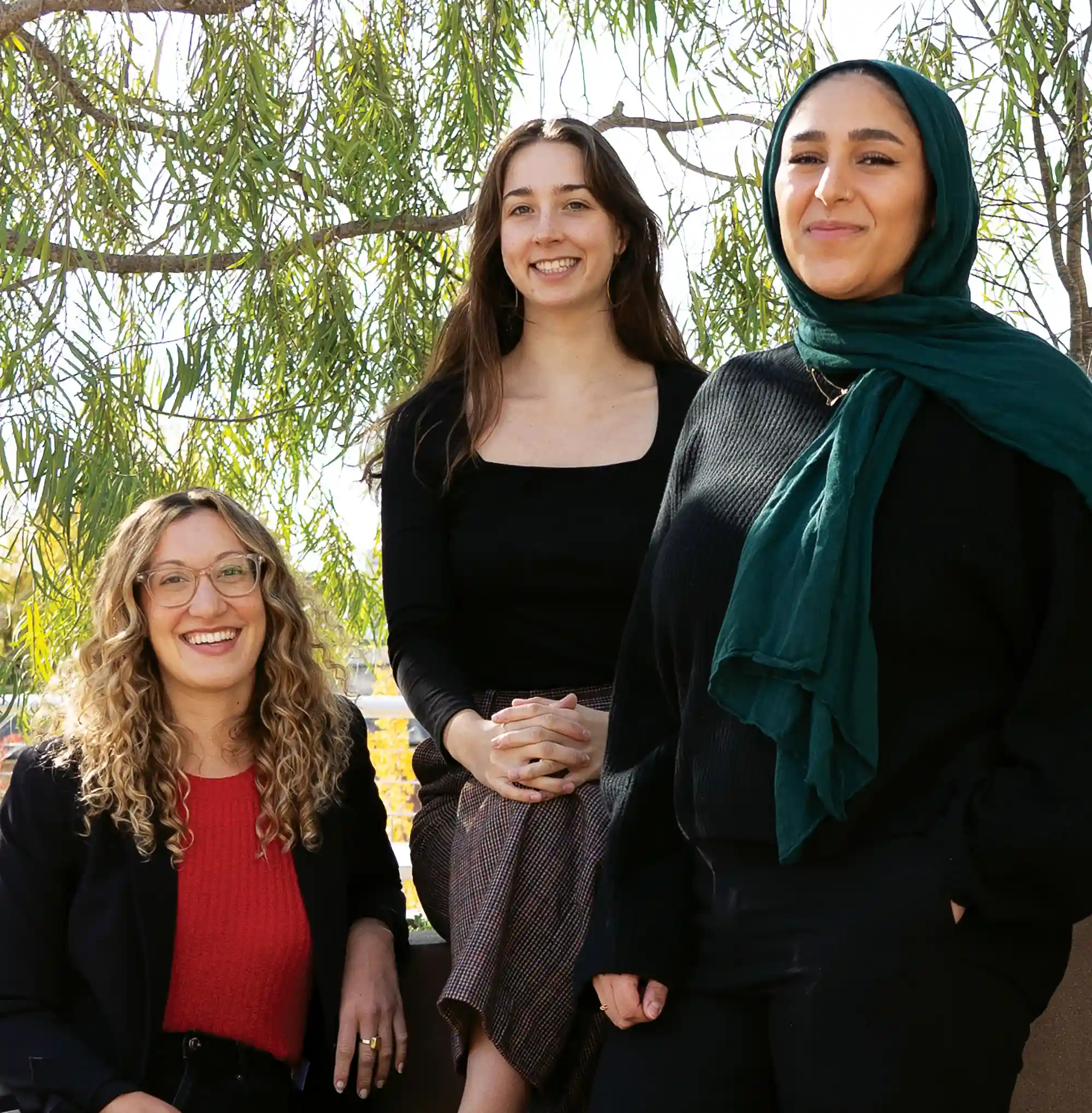  Mia Stange, Sophia Fenn, and Mariam Elbakr posing outside campus
