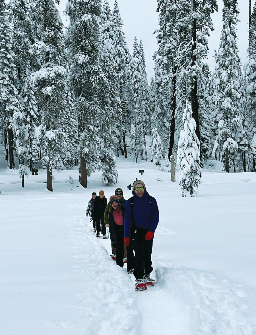 Evan Levy, Natalie Friedberg, Jacob Bendicksen, Emma Lewis, and Cat Chervenak in the snow walking through a trail