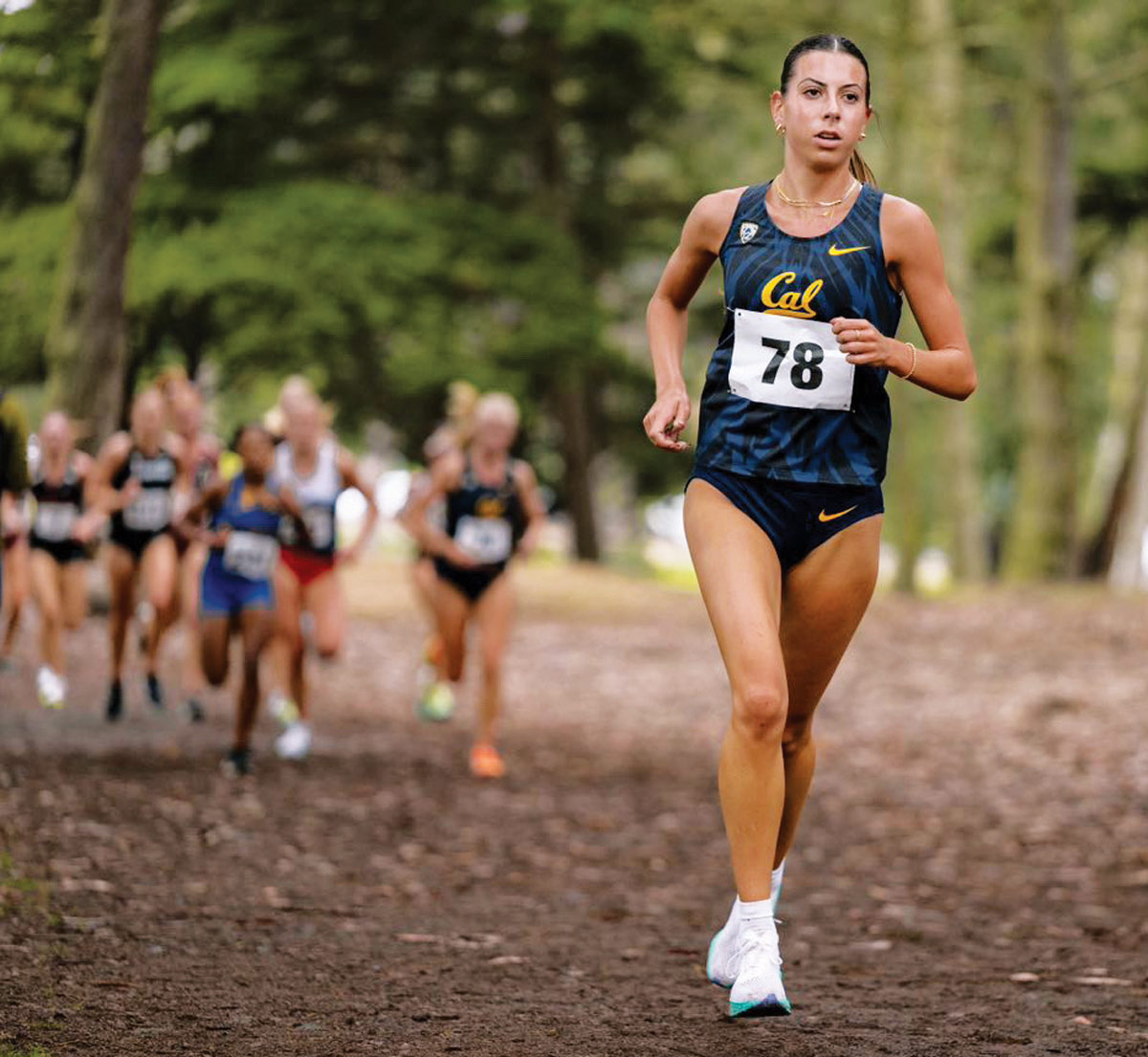 Anastasia Snodgrass wearing her running uniform while running in a wooded area