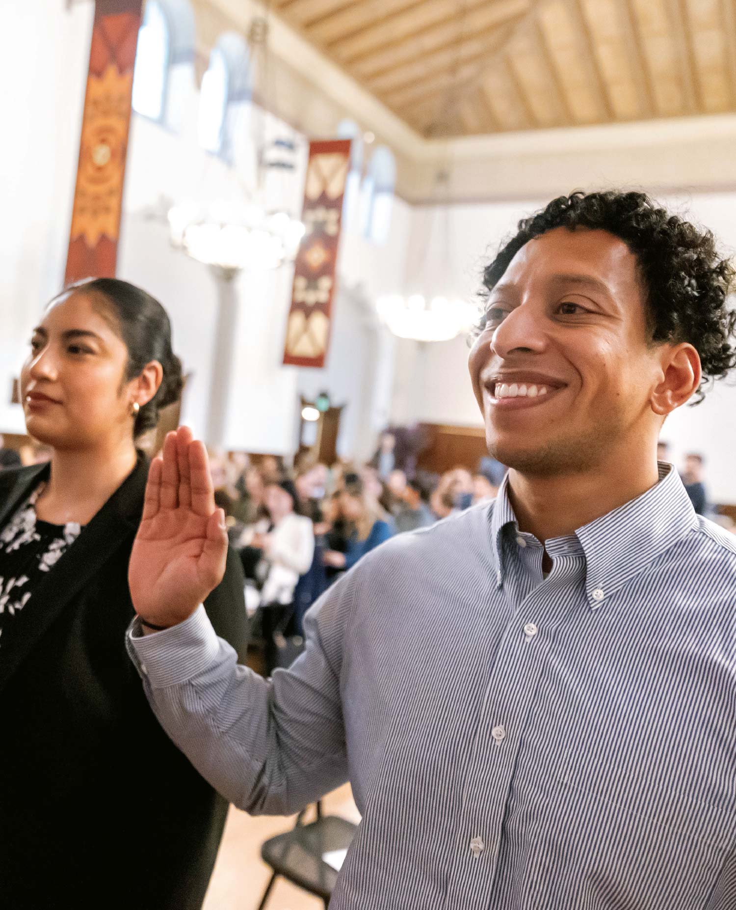 Marcos A. Romero and Cecilia Almaraz with hands raised during UC Berkeley Law’s annual Swearing-In Ceremony